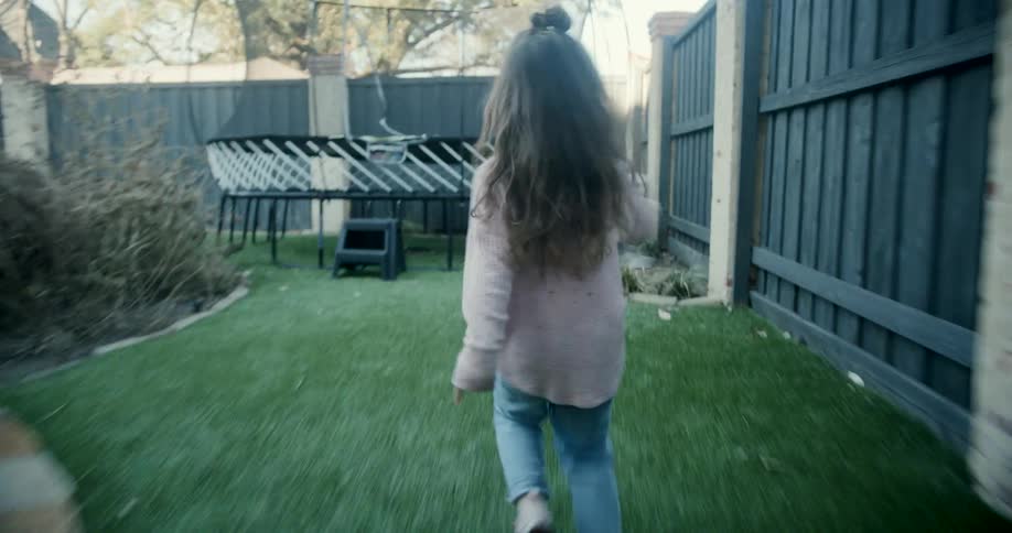 Little girl running around the yard happily