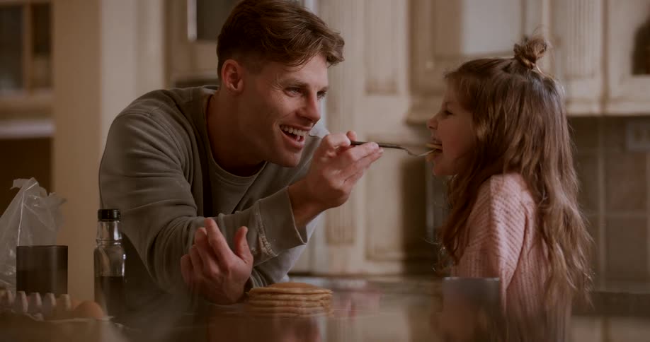 A footage of a man feeding a little girl