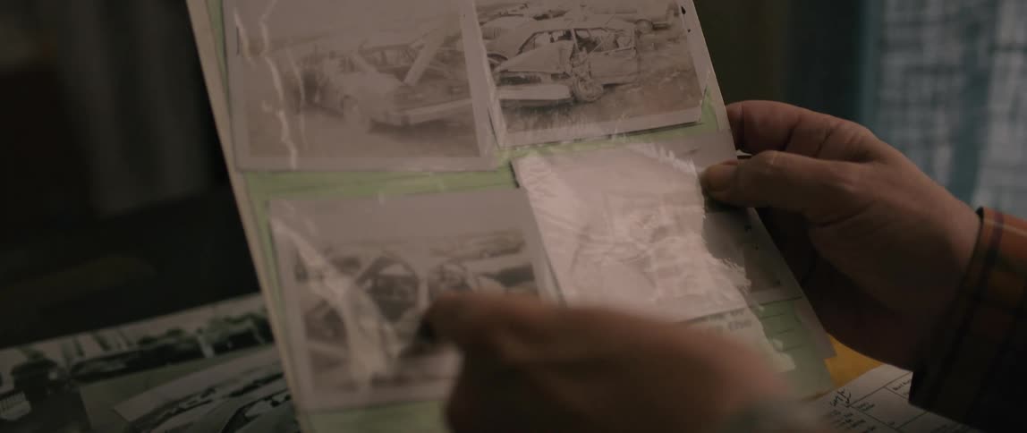 A man pointing at photos on a document