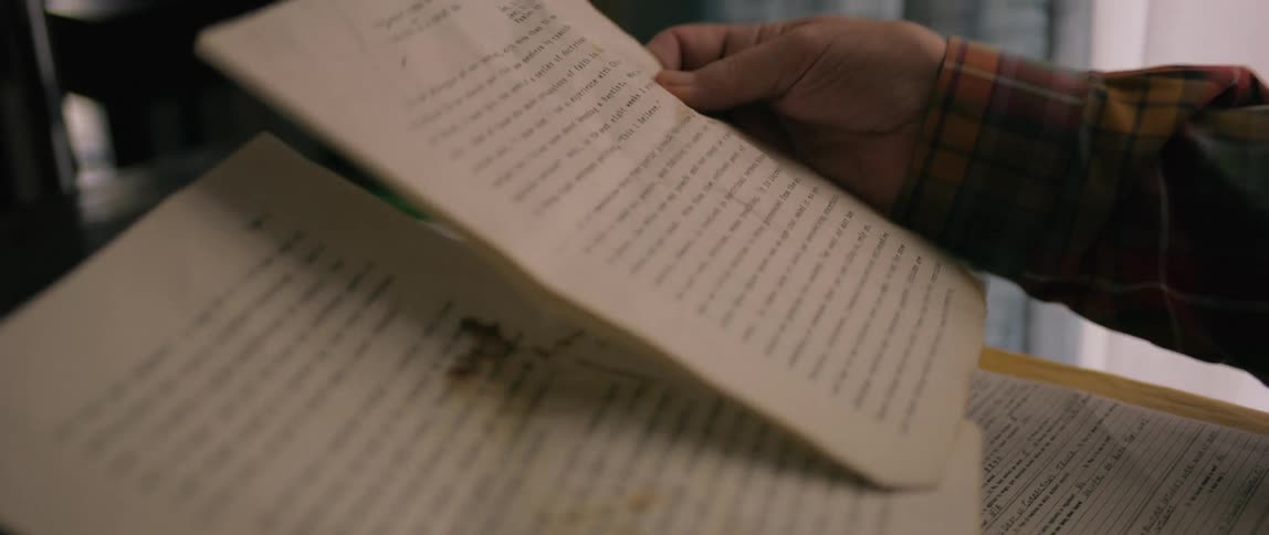 Pair of hands of a person viewing an ancient scripture