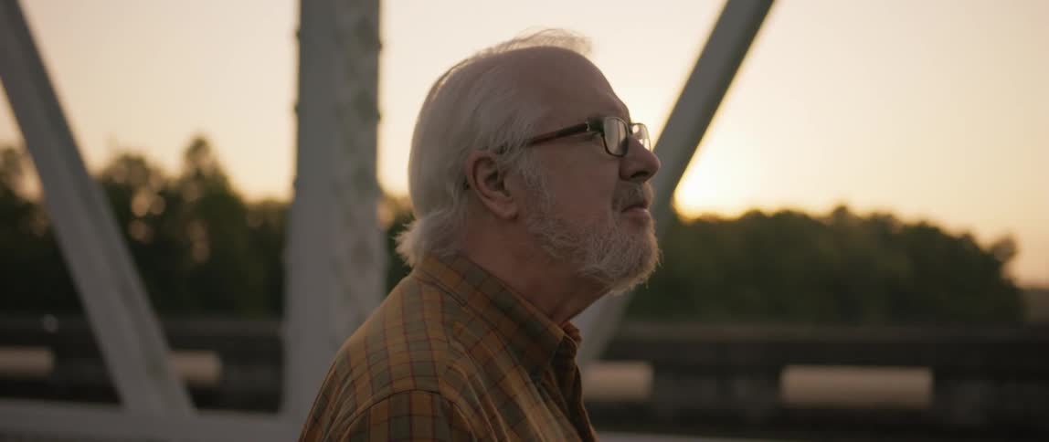 Elderly man in an outdoor environment focused on observing