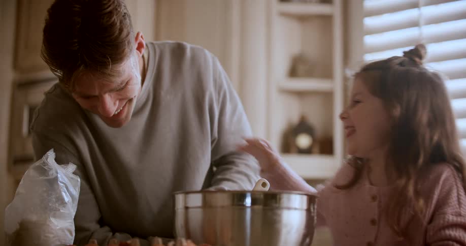 Father and daughter cooking together and playing