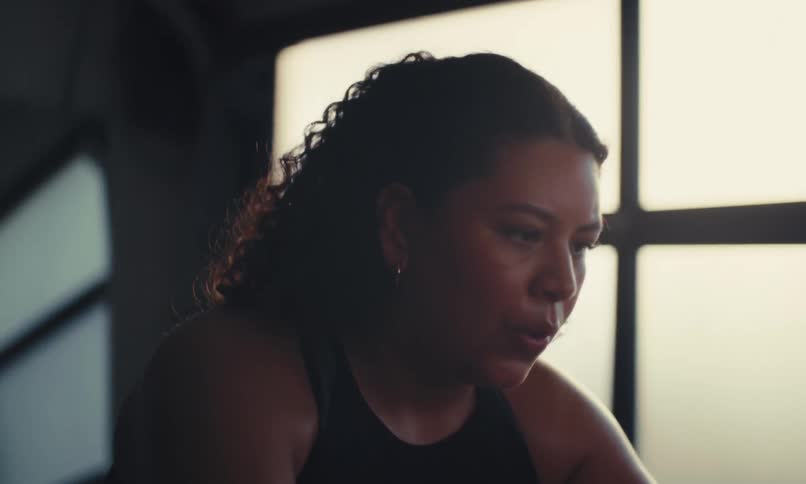 A woman is exercising on a stationary bike at the gym