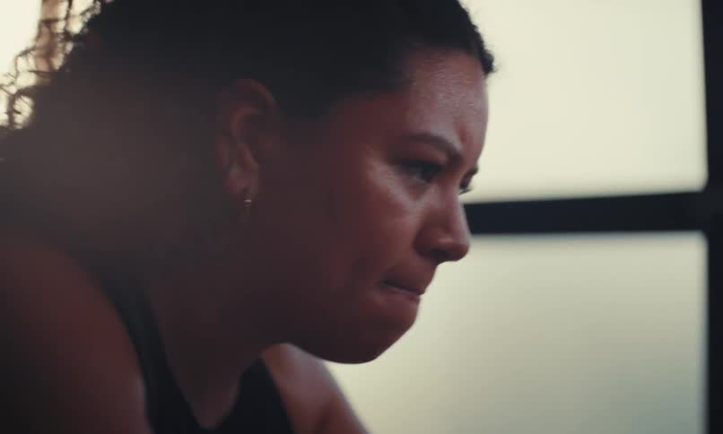 A woman is sweating on the exercise bike