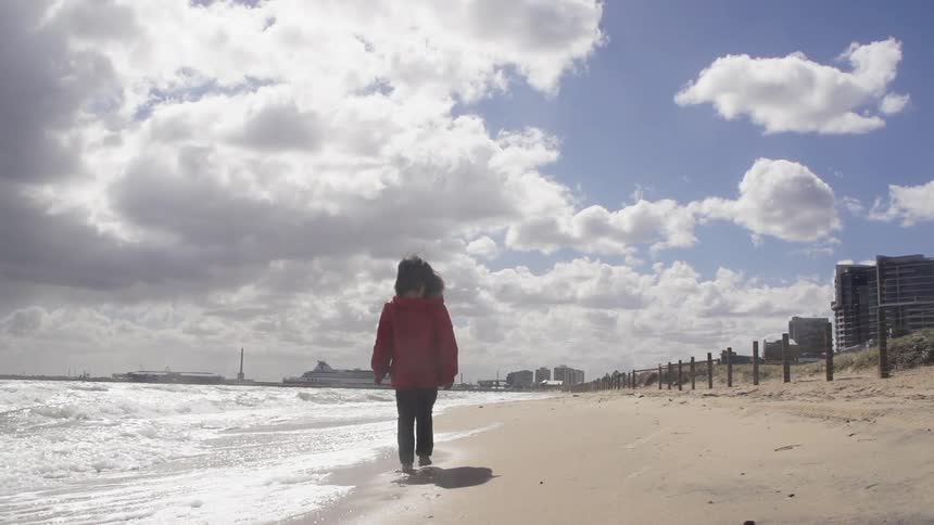 A person in a coat at the beach