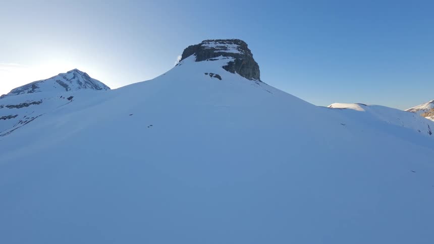 Drone Shot of a Snow-Capped Peak against a cloudless blue sky