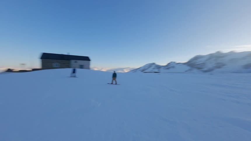 Two people snowboarding on a snowy mountain