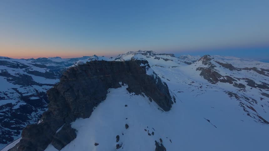 Drone Shot of snowy mountains in a sunrise sky