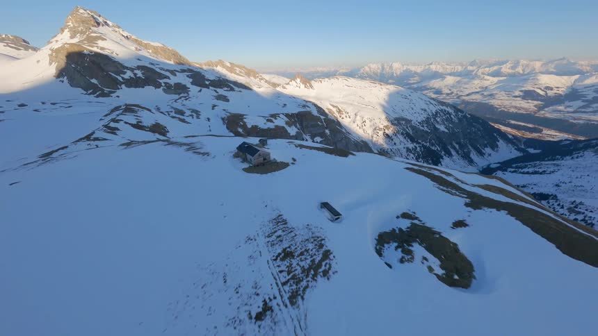 A single cabin is on the peak of a mountain
