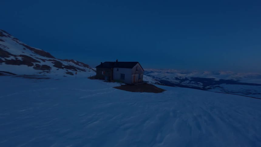Aerial view of a wooden house on a snowy mountain at night