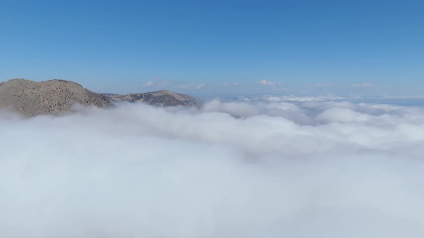 Aerial view of a sea of clouds with mountains in sight