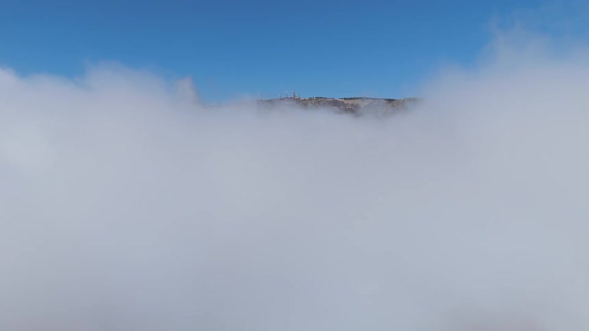 Low lying clouds rise to obscure the top of a hill on a cloudy day