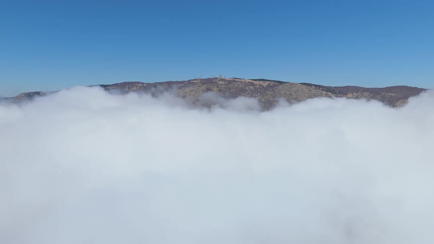 Thick fog hands over most of a mountain range