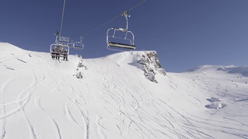 People ride a ski lift in the winter