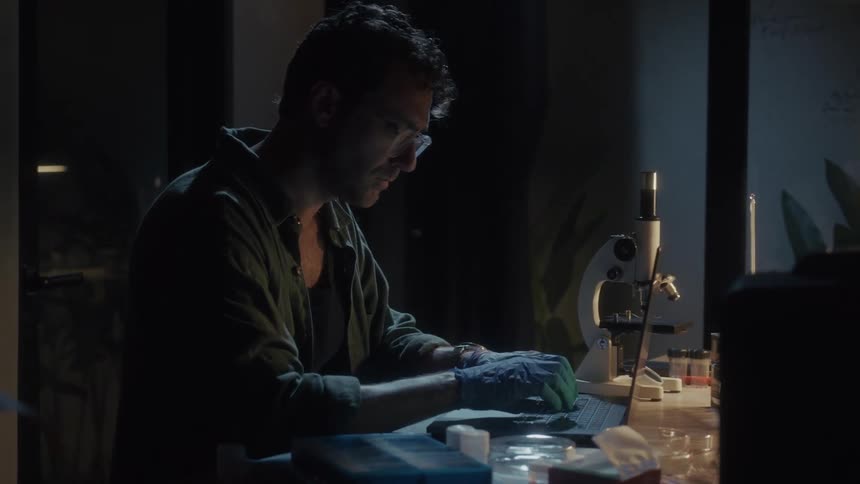 The scientist is typing notes into his laptop