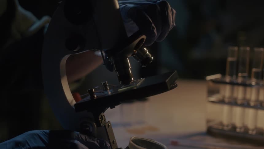 A man in a laboratory using a microscope to analyze samples