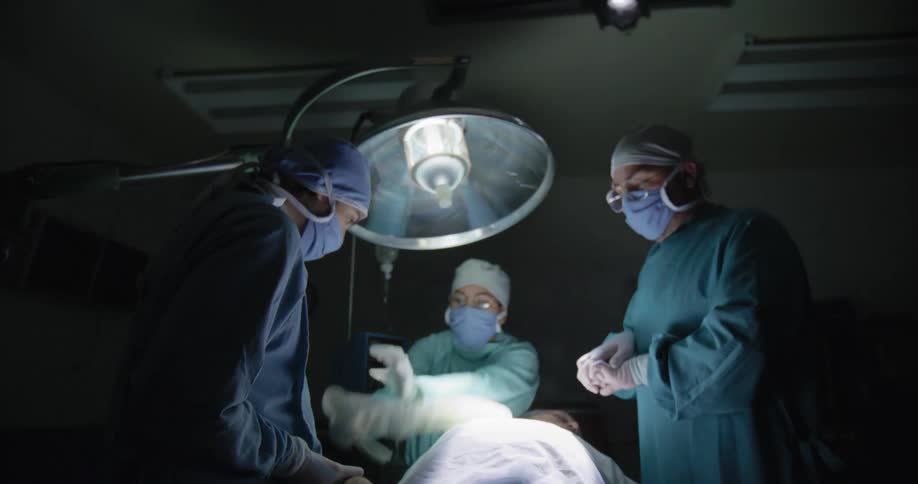 A man in a hospital being resuscitated by three doctors