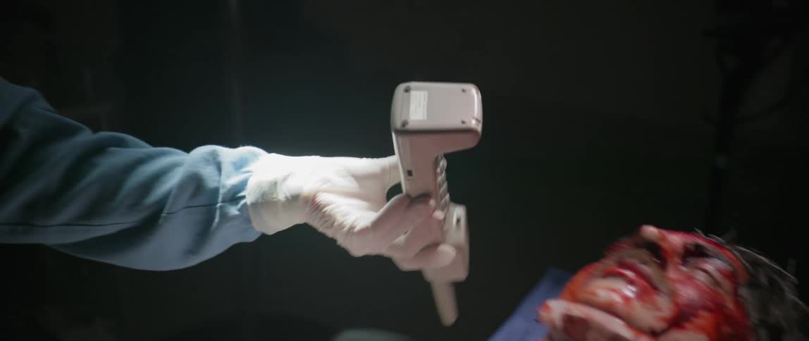 A female healthcare professional is handing the phone over to a patient on the operating table
