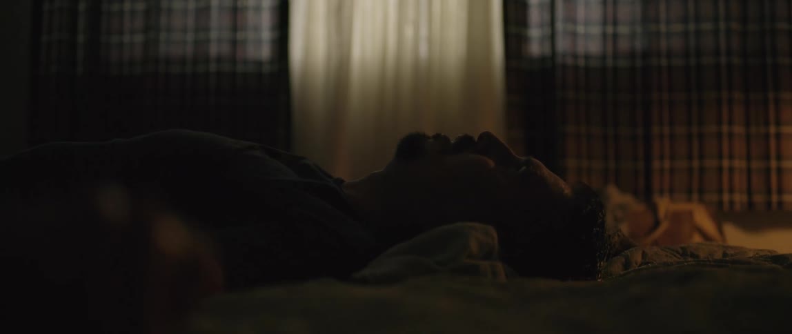A man falls on a bed and takes very deep breaths