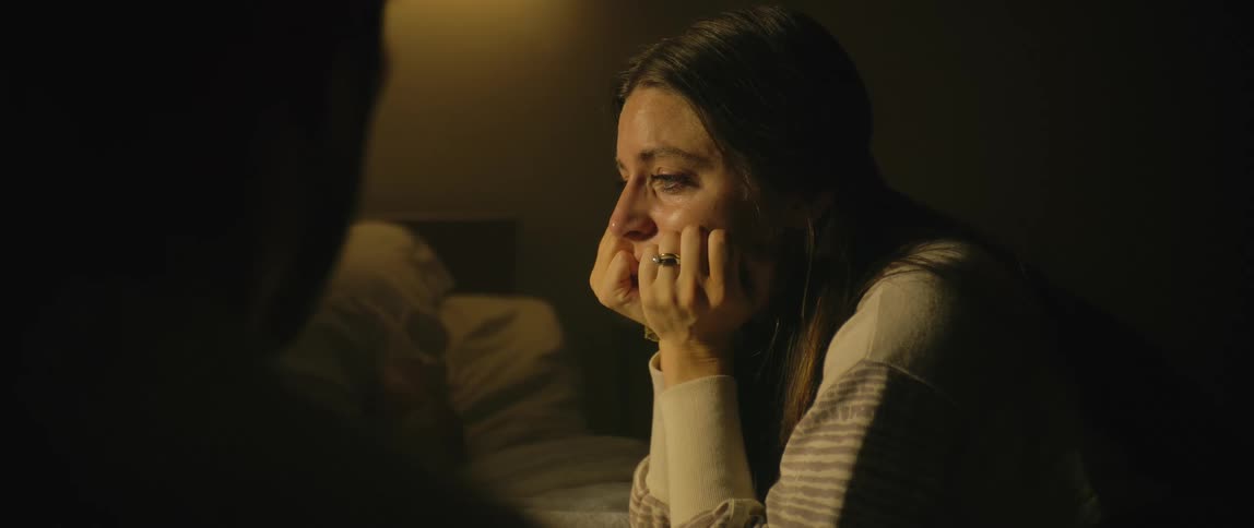 A woman is crying at the beside of the hospital patient