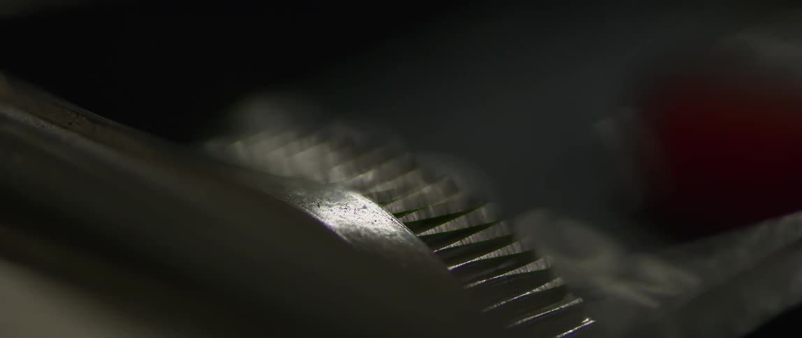 A person winds the gear on the device