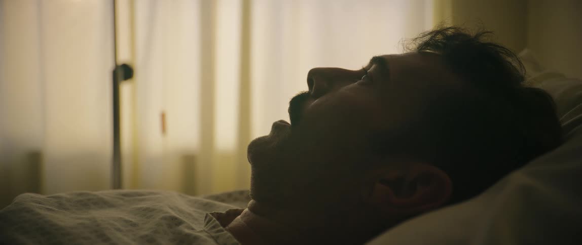 Man wakes up from sleep and turns his head towards the camera