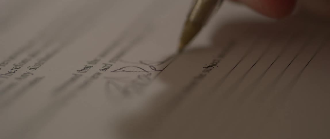 A person signs their signature on the form