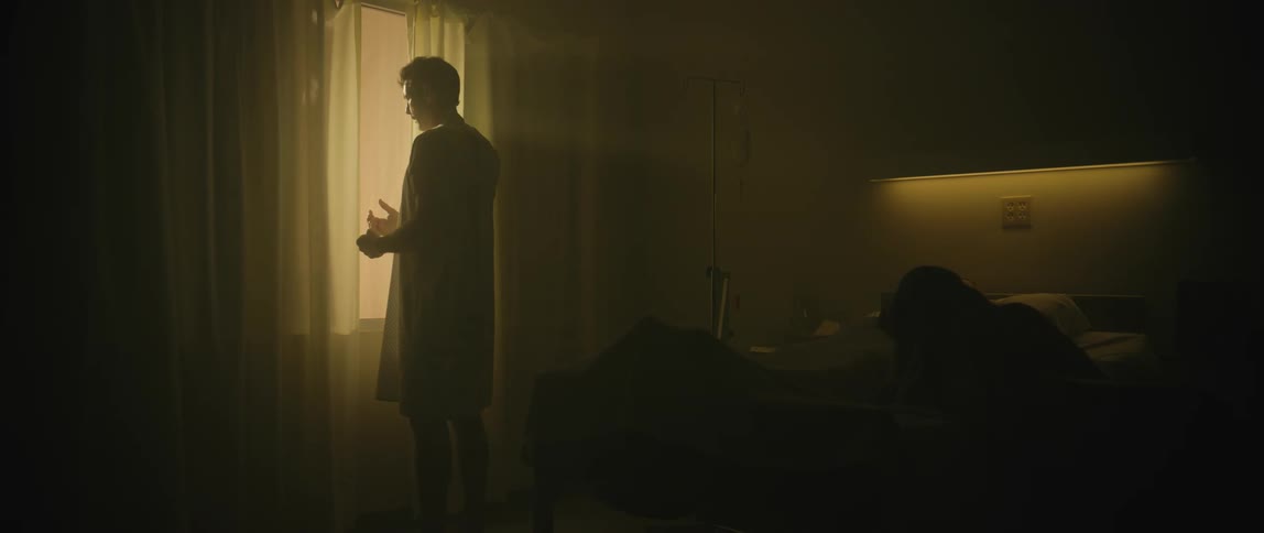 Silhouette of a patient in a hospital window in a dark room