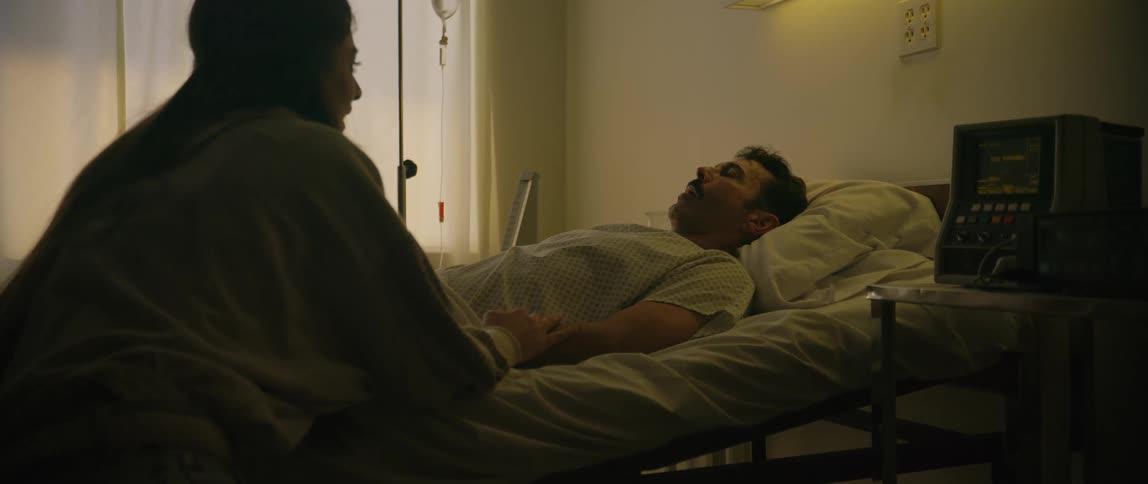 Woman waiting by a hospital bedcries with relief when the patient wakes up