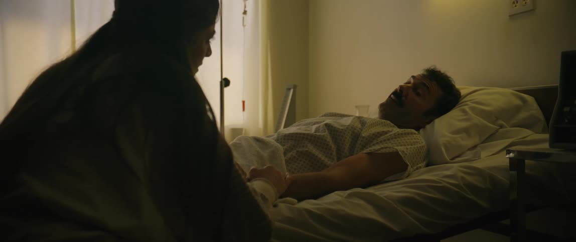 A visitor is talking with a sick hospital patient