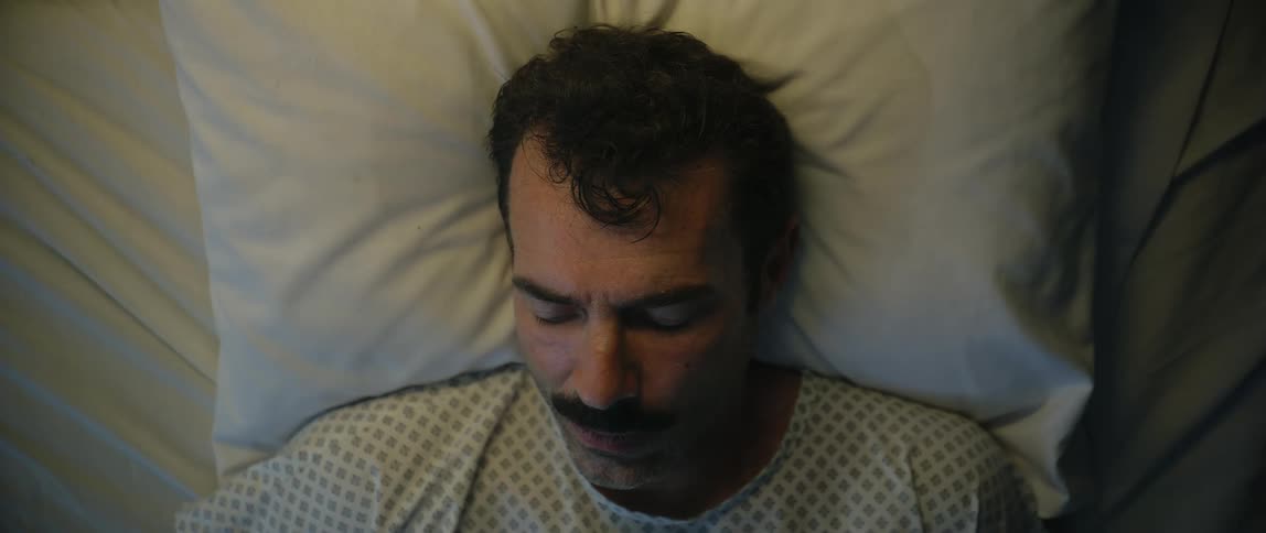 A man is sleeping in the hospital bed