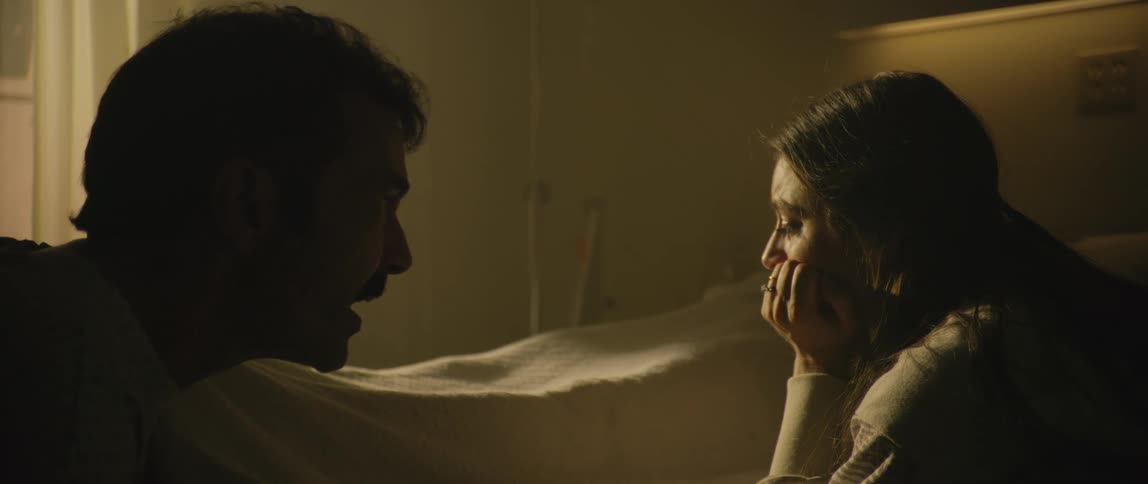 A man yells at a woman while she sits sadly