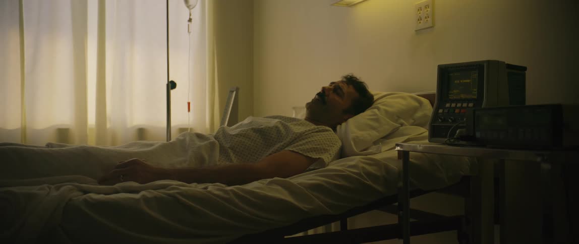 A visitor of a sick patient is holding his hand