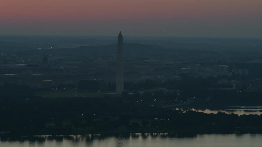 A pillar sits in the city ahead at dawn