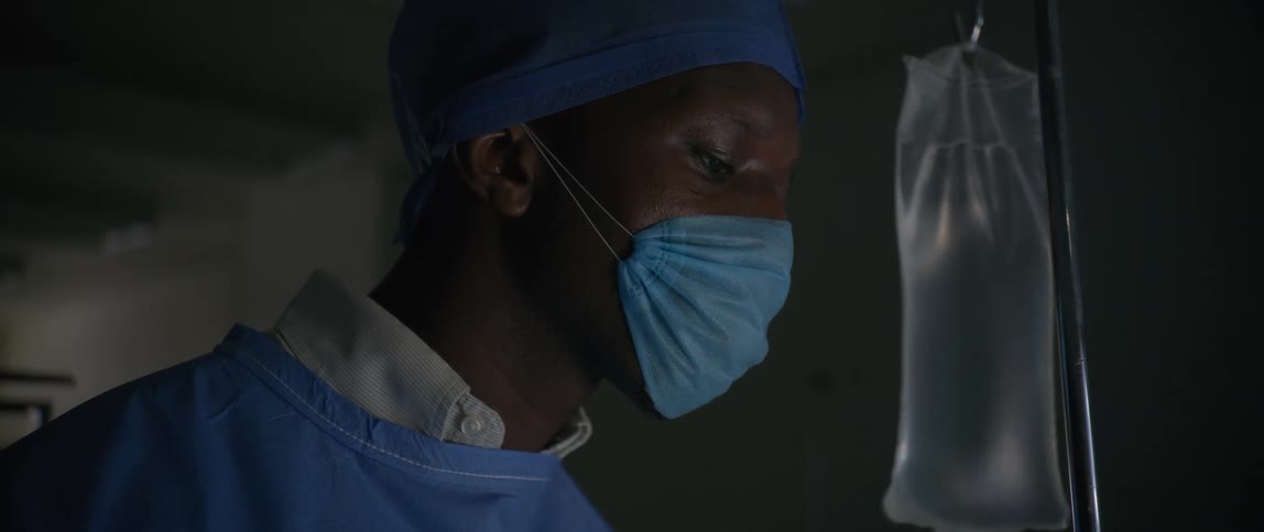 A doctor is standing by the iv bag