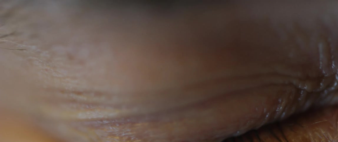 A persons eye with green eyes that is blinking and giving a long blink