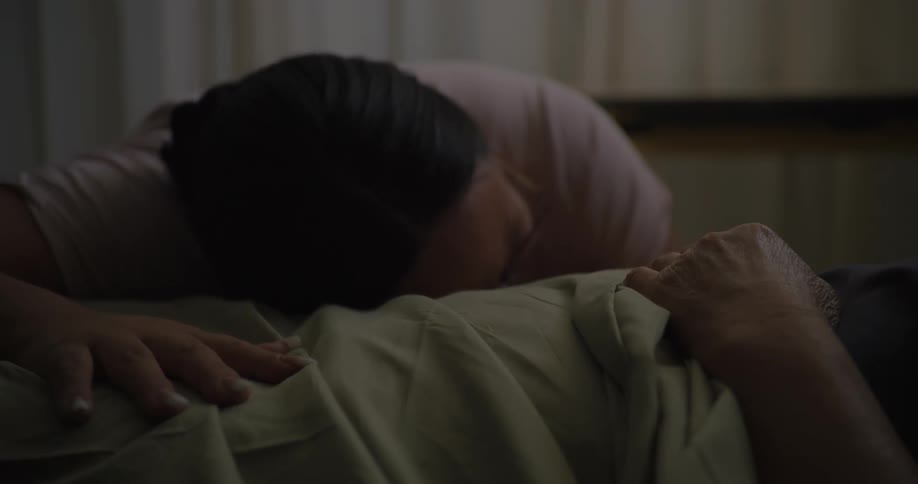 A woman is crying over a person in the hospital