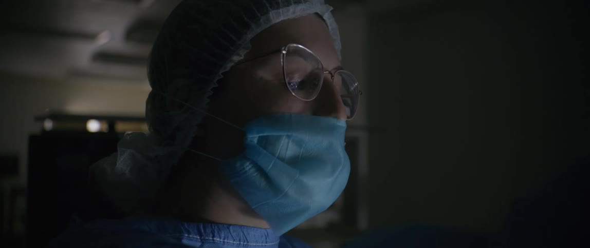 A doctor is pointing and talking in the dark hospital