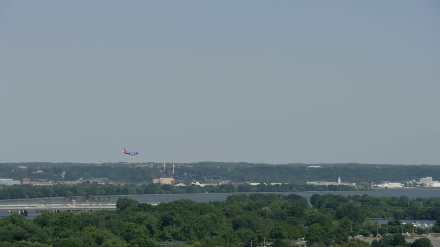 An airplane descends into a city