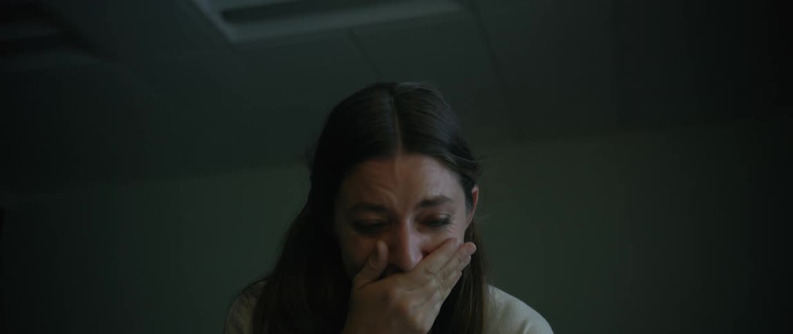 Woman crying and putting her hand over her mouth