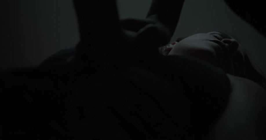 Two people attempt to resuscitate a woman with chest compressions together with a defibrillator
