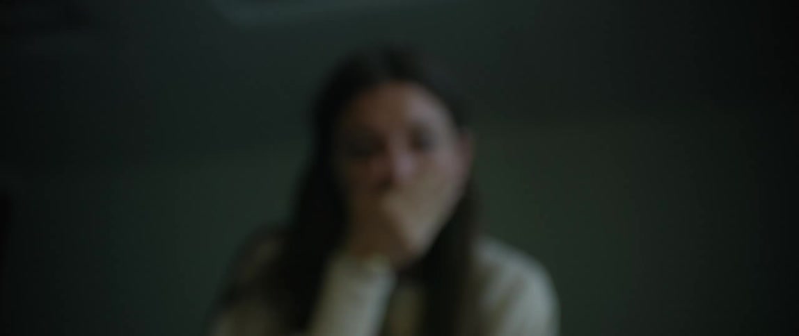 Woman in a room desperately crying