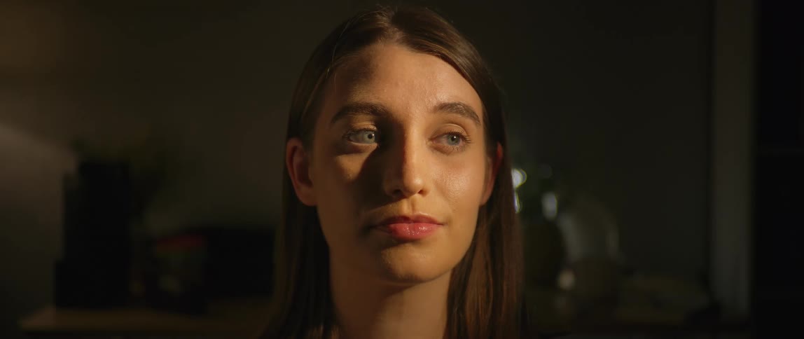 A woman opens her eyes and looks to the side