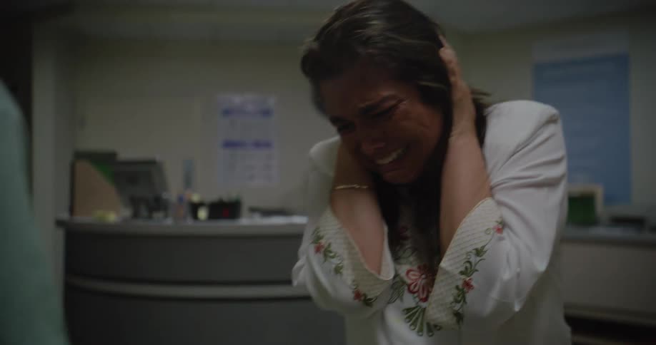 A nurse consoles a hysterical woman in the hospital hallway