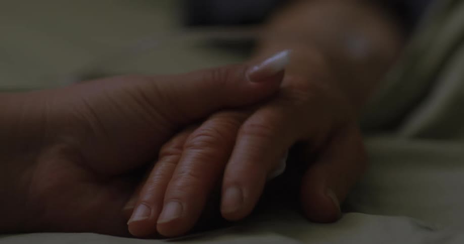 A visitor is holding a hospital patients hand