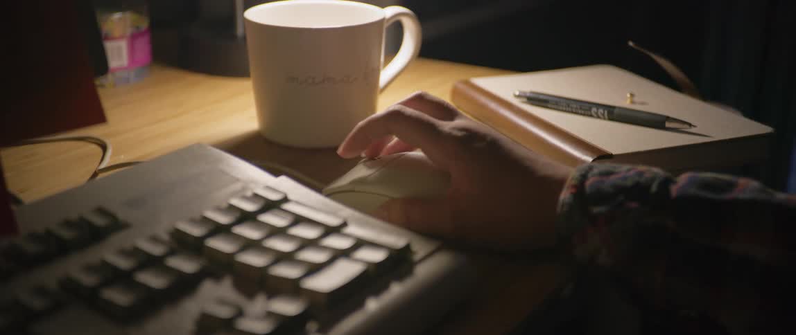 A man working in his office using the mouse and typing on the keyboard