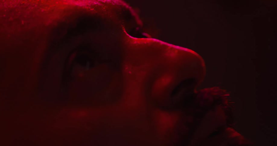 Man under red light therapy is sweating and is looking anxious