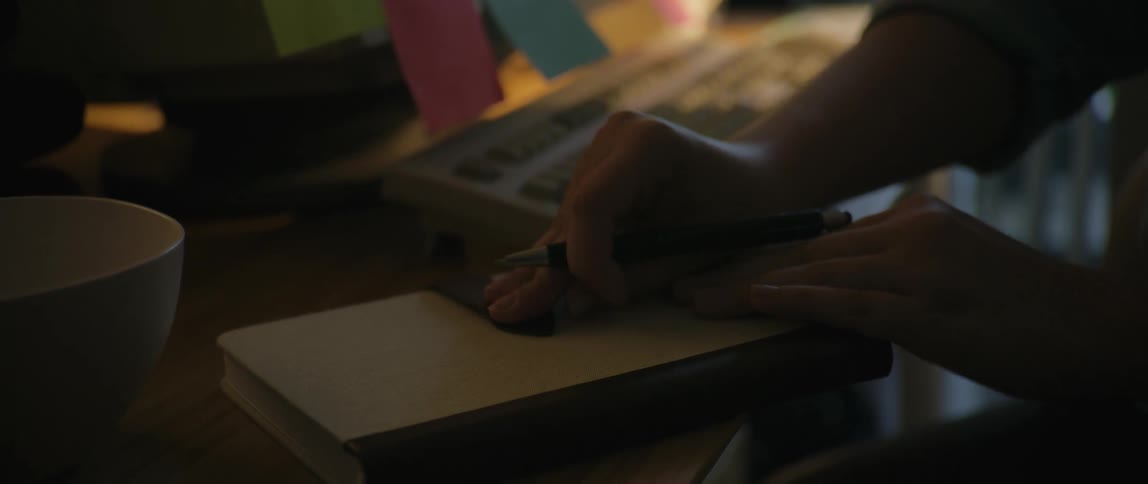 A woman writes in her notebook and uses her notebook