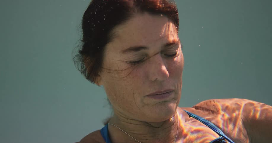A woman holds her breath underwater