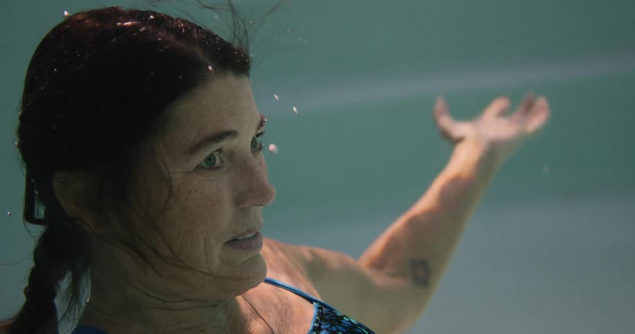A woman dives under the water and then back up